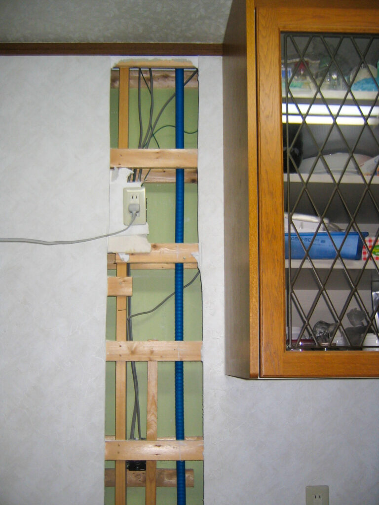 1階の壁をめくって2階へ給水給湯排水管を通すための開口状況(富山市)