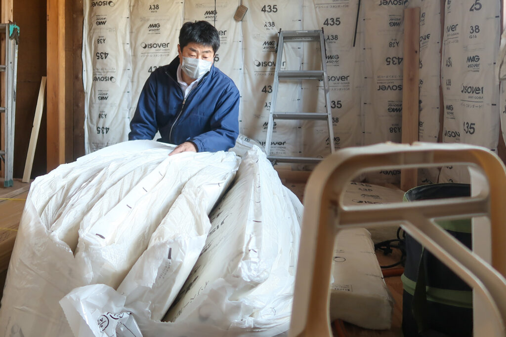 施工した断熱材を確認する小椋建築代表の小椋孝一